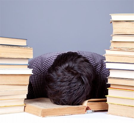The young tired student with the books isolated. Studio shot. Stock Photo - Budget Royalty-Free & Subscription, Code: 400-04346641