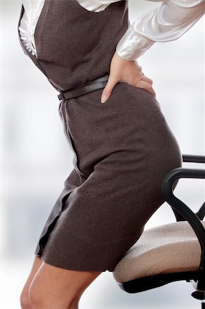 Business woman with back pain after long work on chair. Stock Photo - Budget Royalty-Free & Subscription, Code: 400-04346779