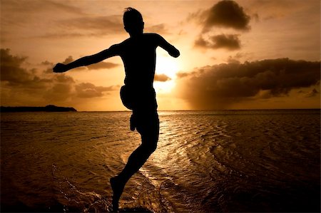 silhouette of boy jumping to the sea at  sunset Stock Photo - Budget Royalty-Free & Subscription, Code: 400-04347036
