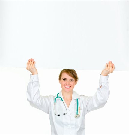 simsearch:400-04351236,k - Smiling medical doctor woman holding blank billboard over her head isolated on white Photographie de stock - Aubaine LD & Abonnement, Code: 400-04347285