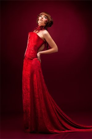 Beautiful girl in red dress over on red background Stockbilder - Microstock & Abonnement, Bildnummer: 400-04349106