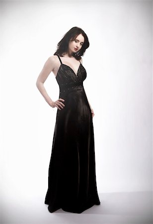 standing young beautiful woman in black dress Foto de stock - Super Valor sin royalties y Suscripción, Código: 400-04340214