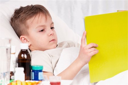 Sick little beautiful boy with book in the bed Stock Photo - Budget Royalty-Free & Subscription, Code: 400-04340444