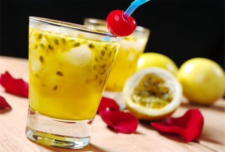 red passion fruit - Passion-fruit juice with a drinking straw and a maraschino cherry as well as passion-fruit and rose petals in the background on wooden board (Selective Focus, Focus on the maraschino cherry) Stock Photo - Budget Royalty-Free & Subscription, Code: 400-04340504