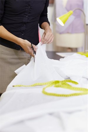 Young hispanic female dressmaker cutting white fabric for bridal gown. Vertical shape, front view, selective focus, copy space Stock Photo - Budget Royalty-Free & Subscription, Code: 400-04340613
