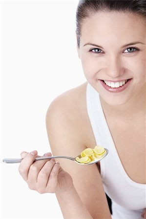 Young attractive woman holding a spoonful of corn flakes on a white background Stock Photo - Budget Royalty-Free & Subscription, Code: 400-04340886