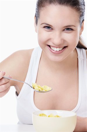 Attractive woman eating corn flakes on a white background Stock Photo - Budget Royalty-Free & Subscription, Code: 400-04340892