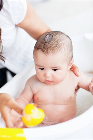 plastic toy family - Adorable baby taking a bath wihile his adorable mother takes care of him at home Stock Photo - Budget Royalty-Free & Subscription, Code: 400-04341629