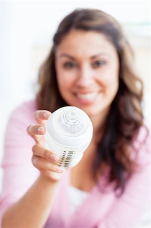 simsearch:400-05320841,k - Close-up of a smiling young mother holding a feeding-bottle at home Stock Photo - Budget Royalty-Free & Subscription, Code: 400-04341633