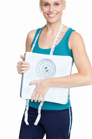 Smiling young woman holding a weight scale looking at the cmera over white backgroud Stock Photo - Budget Royalty-Free & Subscription, Code: 400-04341662