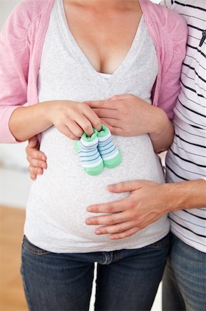 simsearch:400-07322828,k - Close-up of a caucasian pregnant woman holding baby shoes and of her husband at home Fotografie stock - Microstock e Abbonamento, Codice: 400-04341685