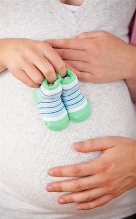 simsearch:400-07322828,k - Close-up of the belly of a pregnant woman holding baby shoes and of her husband at home Fotografie stock - Microstock e Abbonamento, Codice: 400-04341686