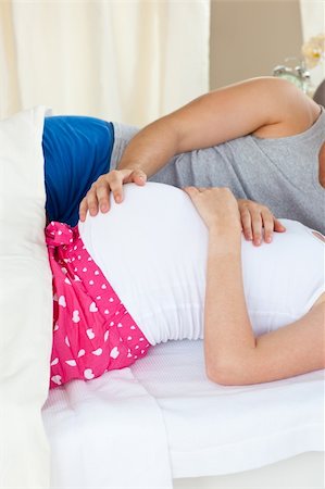 simsearch:400-07322828,k - Close-up of a delighted caucasian pregnant woman lying on bed with her husband in the bedroom Fotografie stock - Microstock e Abbonamento, Codice: 400-04341695