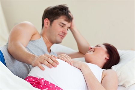 simsearch:400-07322828,k - Joyful pregnant woman lying on bed with her husband at home Fotografie stock - Microstock e Abbonamento, Codice: 400-04341732