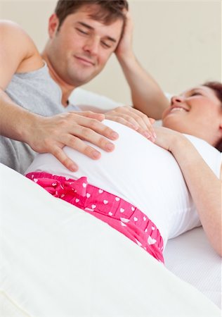 simsearch:400-07322828,k - Happy pregnant woman lying on bed with her husband at home Fotografie stock - Microstock e Abbonamento, Codice: 400-04341733