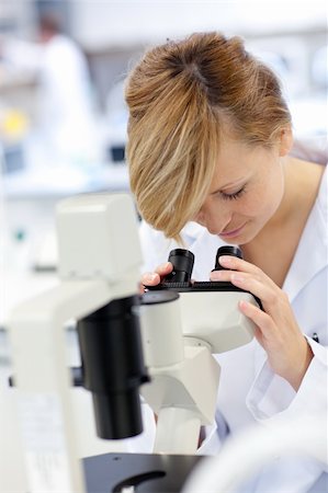 simsearch:400-05670345,k - Serious female scientist using a microscope in her laboratory Photographie de stock - Aubaine LD & Abonnement, Code: 400-04341776