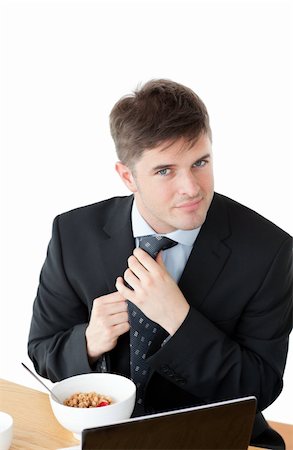 simsearch:400-05741872,k - Elegant businessman having breakfast and touching his tie in front of his laptop against a white background Stock Photo - Budget Royalty-Free & Subscription, Code: 400-04341835