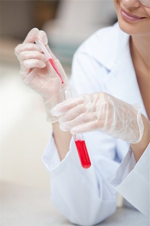 simsearch:400-05670362,k - Close-up of a smiling scientist holding a pipette and a test tube in her lab Stock Photo - Budget Royalty-Free & Subscription, Code: 400-04341839