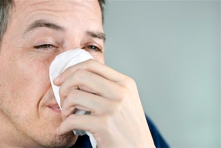 Close-up of a man holding a  tissue on his nose. Stock Photo - Budget Royalty-Free & Subscription, Code: 400-04342782