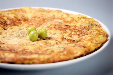 A picture of a typical Spanish tortilla decorated with olives over light background Stock Photo - Budget Royalty-Free & Subscription, Code: 400-04342843