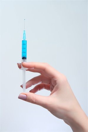 doctor preparing shot - Woman holds in her hand medical syringe with blue solution Stock Photo - Budget Royalty-Free & Subscription, Code: 400-04343608