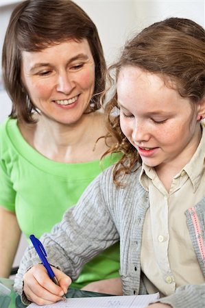 Teenager girl sitting together with her mother and showing her homework Stock Photo - Budget Royalty-Free & Subscription, Code: 400-04343897