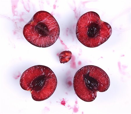 simsearch:400-04287445,k - image of fresh cherries cut in halves with seed  and cherry juice on white Stockbilder - Microstock & Abonnement, Bildnummer: 400-04354500