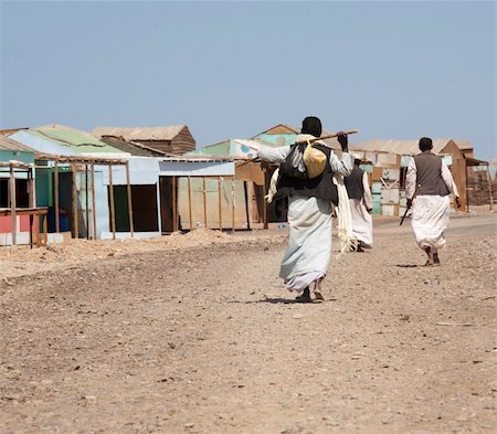 Three local egyptian men walking up dirt road in a rural african settlement Stock Photo - Budget Royalty-Free & Subscription, Code: 400-04354726