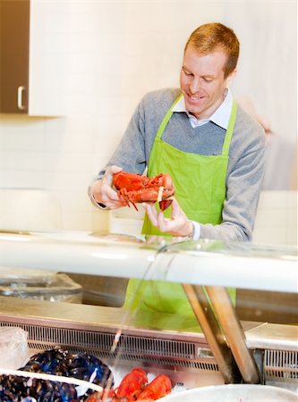 A fresh fish counter in a grocery store - clerk with a lobster Foto de stock - Super Valor sin royalties y Suscripción, Código: 400-04356289