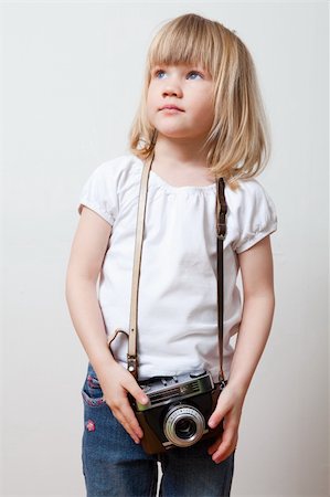 people holding camera slr - Little girl with an old camera. Studio shot. Stock Photo - Budget Royalty-Free & Subscription, Code: 400-04356766
