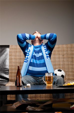 fat men in uniform - soccer fan is sitting on sofa with beer at home Photographie de stock - Aubaine LD & Abonnement, Code: 400-04358882