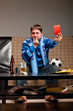 fat men in uniform - soccer fan is sitting on sofa with beer and showing red card at home Stock Photo - Budget Royalty-Free & Subscription, Code: 400-04358894