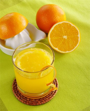 drink coaster - Fresh orange juice with orange slice in glass and squeezer with oranges in background on green table mat (Selective Focus) Stock Photo - Budget Royalty-Free & Subscription, Code: 400-04359328