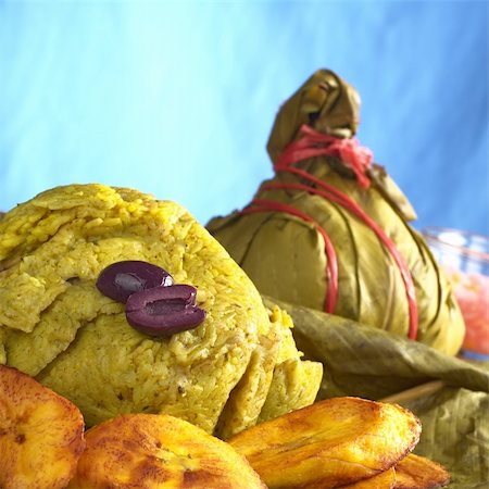 food peru - Traditional Peruvian food called Juane from the jungle area, in which rice, eggs and different kind of meat is wrapped into bijao leaves, and is served with fried plantains and black olives (Selective Focus, Focus on the olives and the front of the rice) Stock Photo - Budget Royalty-Free & Subscription, Code: 400-04359749