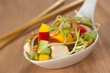simsearch:400-04854606,k - Fresh Asian salad with chicken, mango, cucumber, bean sprouts, red bell pepper and peanuts on white ceramic spoon with wooden chopsticks in the back (Selective Focus, Focus on the front of the food) Foto de stock - Royalty-Free Super Valor e Assinatura, Número: 400-04350350