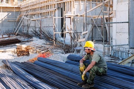 Construction worker resting on piles of reinforcement steel bars, in a busy construction site Stock Photo - Budget Royalty-Free & Subscription, Code: 400-04350599