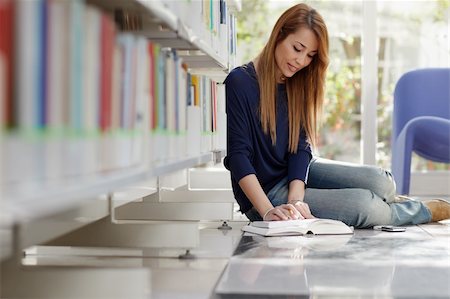 female college student sitting on floor in library, reading book and taking notes. Horizontal shape, full length, side view Stock Photo - Budget Royalty-Free & Subscription, Code: 400-04352152