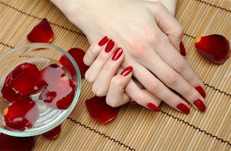 salon background - Beautiful hand with perfect nail red manicure and rose petals. Stock Photo - Budget Royalty-Free & Subscription, Code: 400-04353218