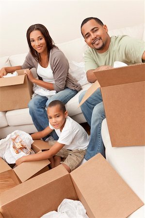 father and son with toy airplane - African American family, parents and son, unpacking boxes and moving into a new home, The adults are unpacking crockery and homeware, the child is unpacking a toy airplane. Stock Photo - Budget Royalty-Free & Subscription, Code: 400-04353331