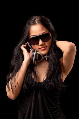 A young asian girl in a black dress and sunglassses listening to music from dj style headphones. Photographie de stock - Aubaine LD & Abonnement, Code: 400-04353830