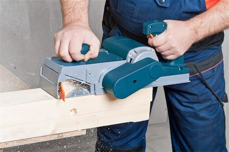 simsearch:400-04856931,k - Close-up of a construction worker's hand and power tool while planing a piece of wood trim for a project. Photographie de stock - Aubaine LD & Abonnement, Code: 400-04364350