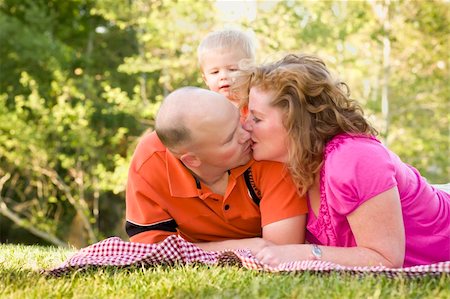simsearch:400-06172843,k - Affectionate Couple Kiss as Adorable Son Watches in the Park. Stock Photo - Budget Royalty-Free & Subscription, Code: 400-04366654