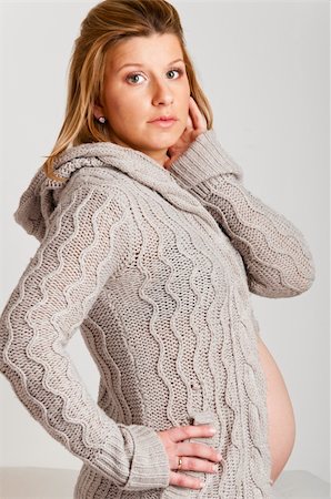 simsearch:400-04859723,k - fashionable pregnant woman wearing woolen cardigan on gray background Fotografie stock - Microstock e Abbonamento, Codice: 400-04366898