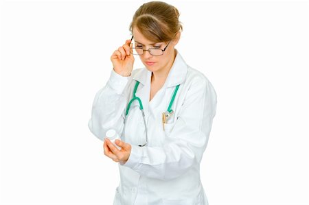 simsearch:400-07099882,k - Concentrated medical female doctor in eyeglasses reading name of drug isolated on white Photographie de stock - Aubaine LD & Abonnement, Code: 400-04367307
