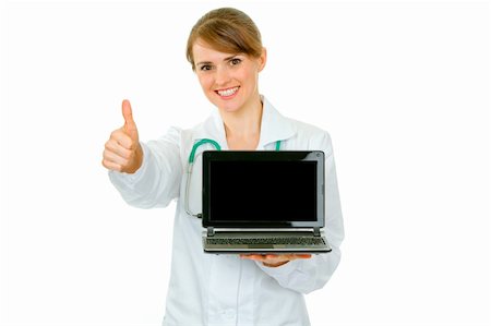 Smiling  medical doctor woman holding laptop with blank screen and showing thumbs up gesture isolated on white Stock Photo - Budget Royalty-Free & Subscription, Code: 400-04367302