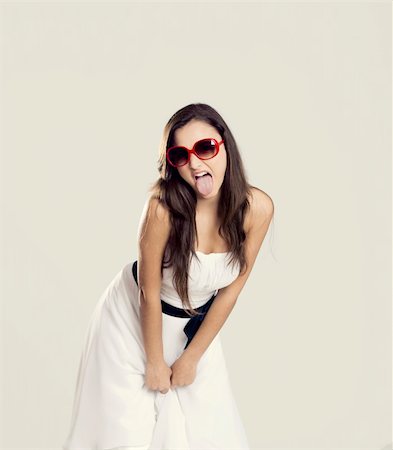 Beautiful young woman with a white dress and sunglasses showing her tongue out Stock Photo - Budget Royalty-Free & Subscription, Code: 400-04367372