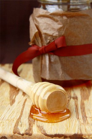 pouring wheat - jar with honey and wooden spoon for honey on a brown background Foto de stock - Super Valor sin royalties y Suscripción, Código: 400-04368818