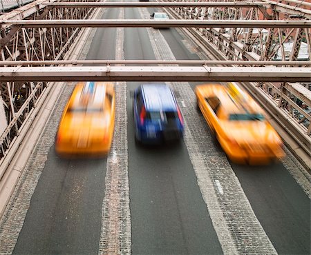 Two New York city taxis speeding across the Brooklyn Bridge surround a small blue car. Note that the cars show motion blur. Stock Photo - Budget Royalty-Free & Subscription, Code: 400-04369904