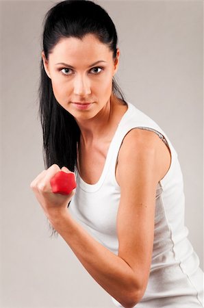 simsearch:400-04361224,k - sporty woman is exercising with red barbell on grey background and looking at camera Stock Photo - Budget Royalty-Free & Subscription, Code: 400-04361220