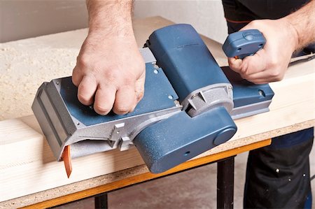 simsearch:400-04856931,k - Close-up of a construction worker's hand and power tool while planing a piece of wood trim for a project. Foto de stock - Royalty-Free Super Valor e Assinatura, Número: 400-04362401